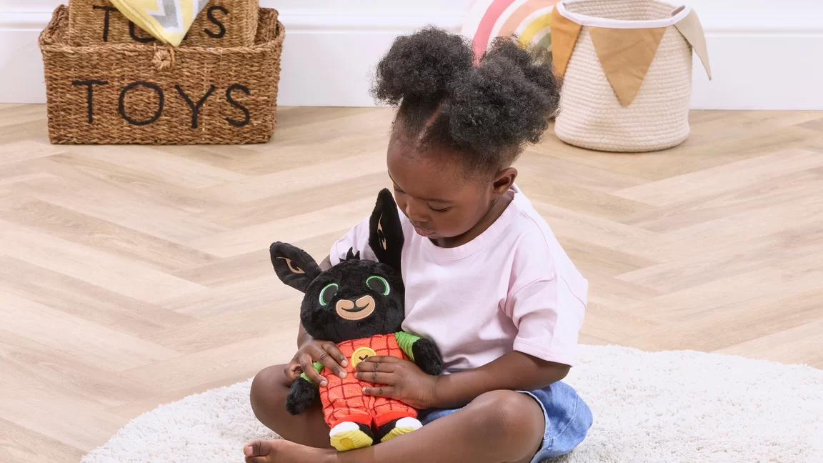 youn girl playing with Bing talking soft toy