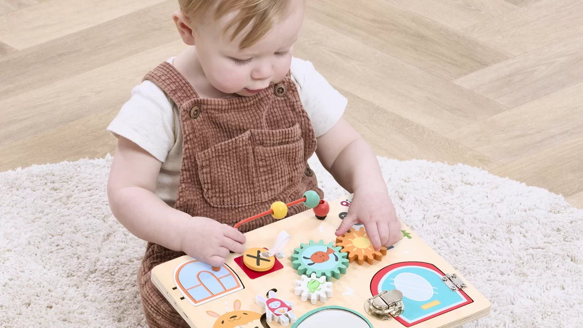 baby playing with wooden Busy board